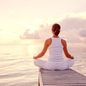 Yoga pose by the ocean during sunset